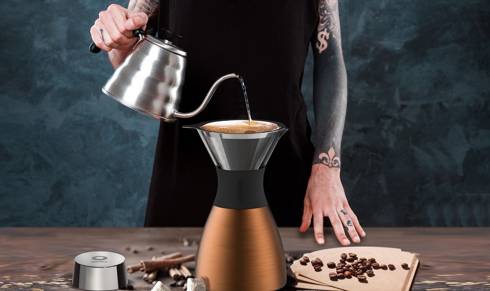 Young tattooed male barista brewing coffee. Alternative method aeropress. Copy space.